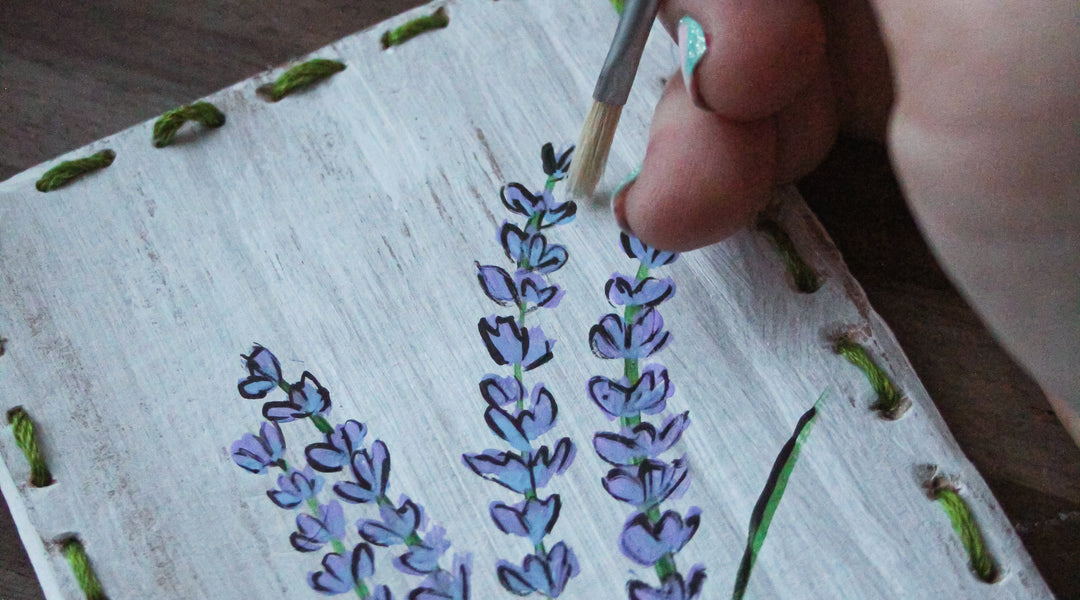A Bella Luna upcycled card with lavender painted on it sits on a table.