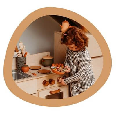 A child plays with the Classic Wooden Kitchen.