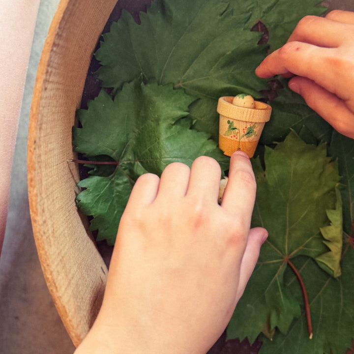 Grapat Lucky Lucky 5th Edition - a close up of a small wooden pot with chiuldren's hands playing a big wooden pot - Bella Luna Toys