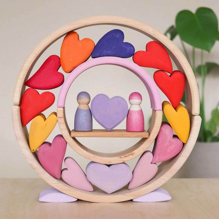 Wooden toy with colorful hearts and peg people on a neutral background