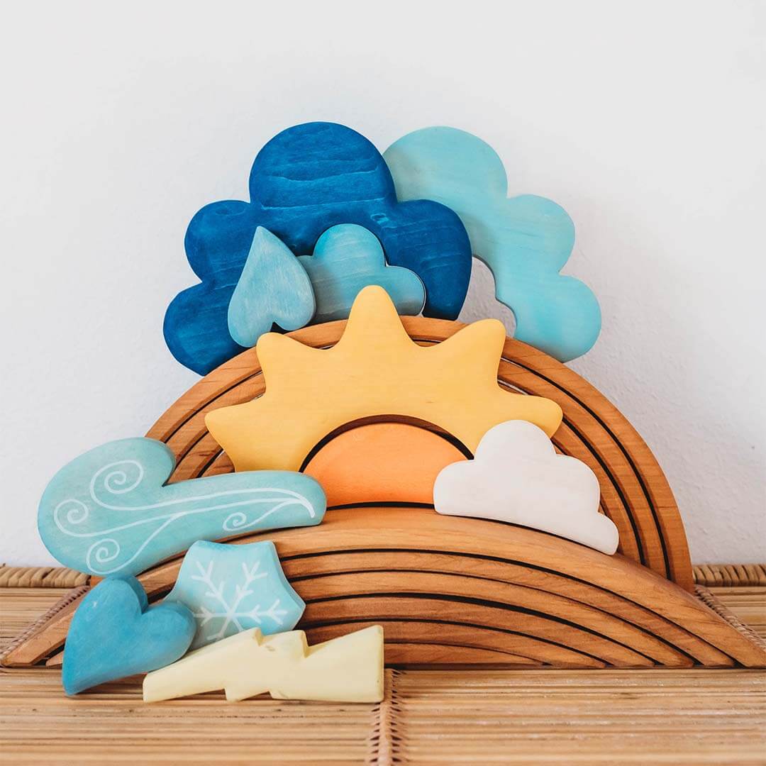 Wooden Toys with a sun, clouds, and wind on a wooden base against a white background.