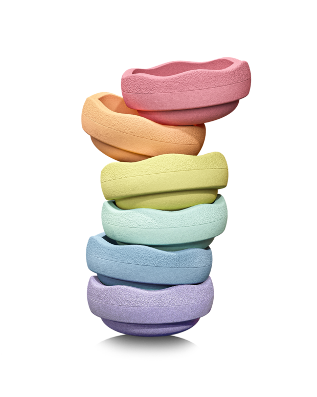 Stack of seven colorful Stapelstein Original Pastel Rainbow stones arranged in a vertical tower, showcasing red, orange, yellow, green, turquoise, blue, and violet stones on a transparent background.