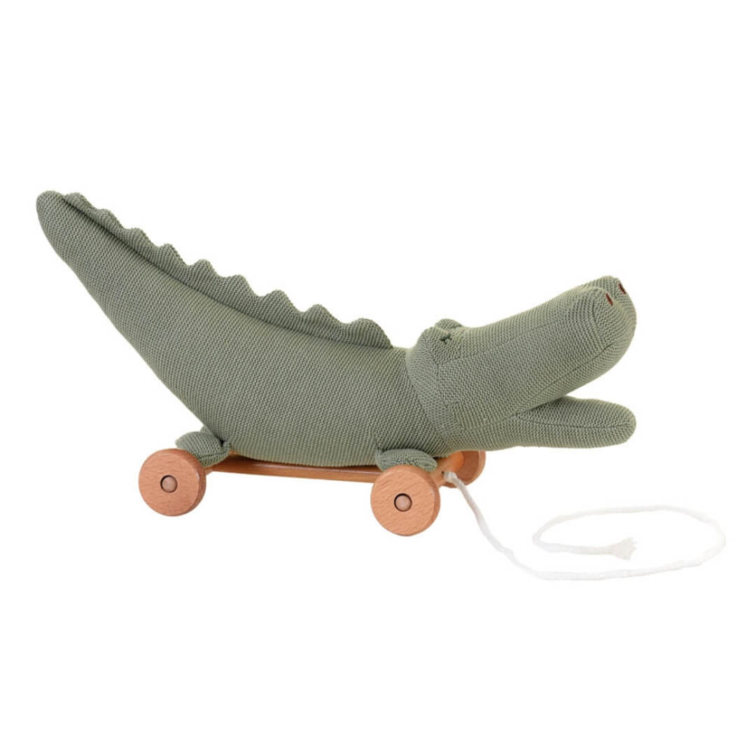 Green knitted alligator toy with wheels on a white background
