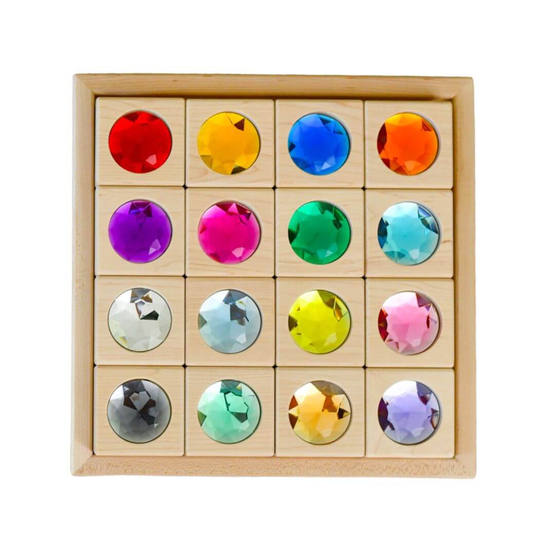 Colorful gemstone puzzle in a wooden box on a white background
