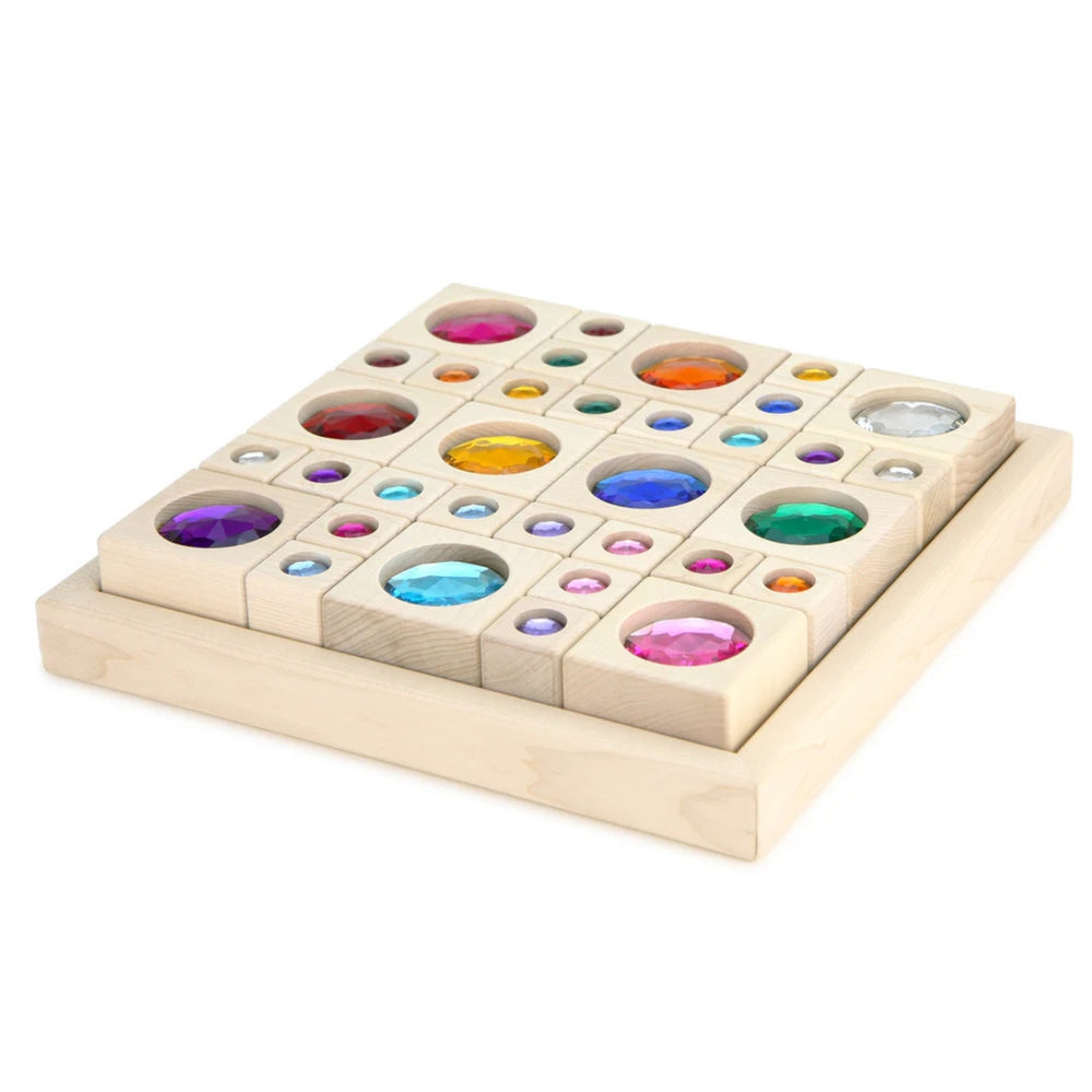 Wooden display tray holding 34 solid maple building blocks with bright, colorful acrylic gems in two assorted sizes and with a variety of gem colors.