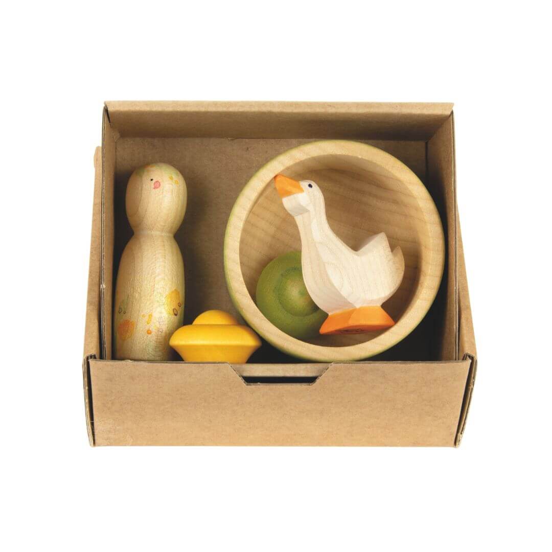 Open box view of the Hello Summer set, revealing the neatly arranged seasonal pieces inside: a painted Nin figure, Ostheimer goose, wooden bowl, and two flower mandala pieces nestled together.