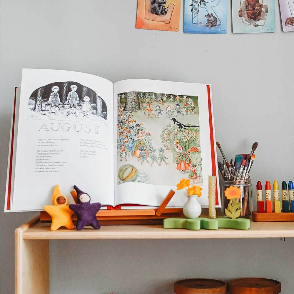 Open book on a wooden surface with decorative items and stationery.