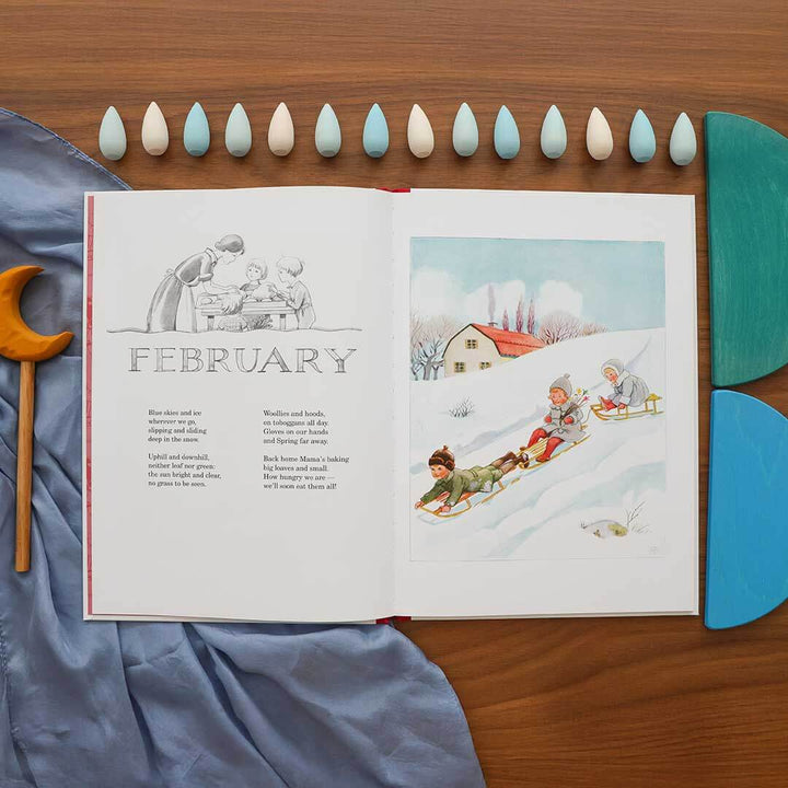 Open book showing illustrations of children sledding on a snowy day with the word 'February' at the top.