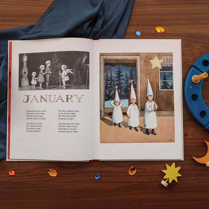 Open book showing illustrations and text on a wooden surface with decorative items.