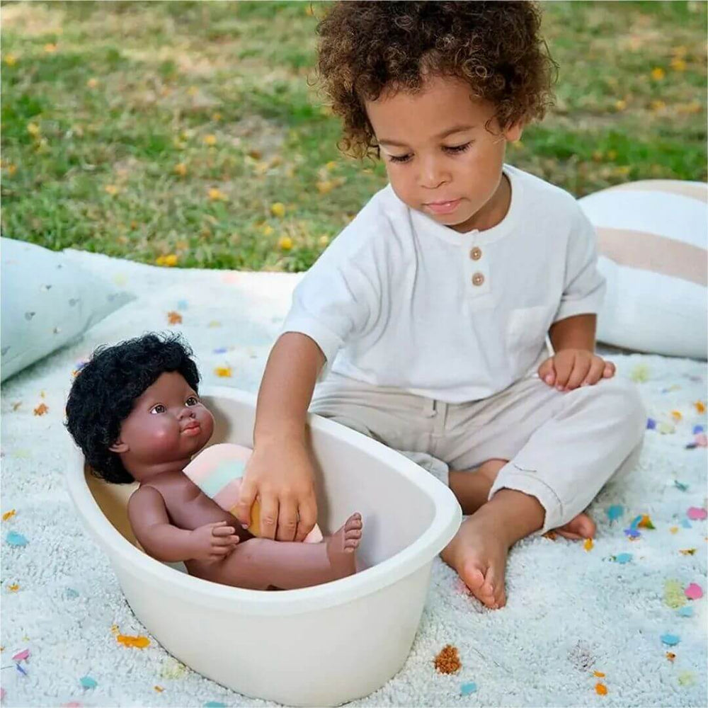 Miniland - Child bathing a Miniland realistic doll in Miniland doll bathtub with rainbow sponge, outside while sitting on a blanket- Bella Luna Toys