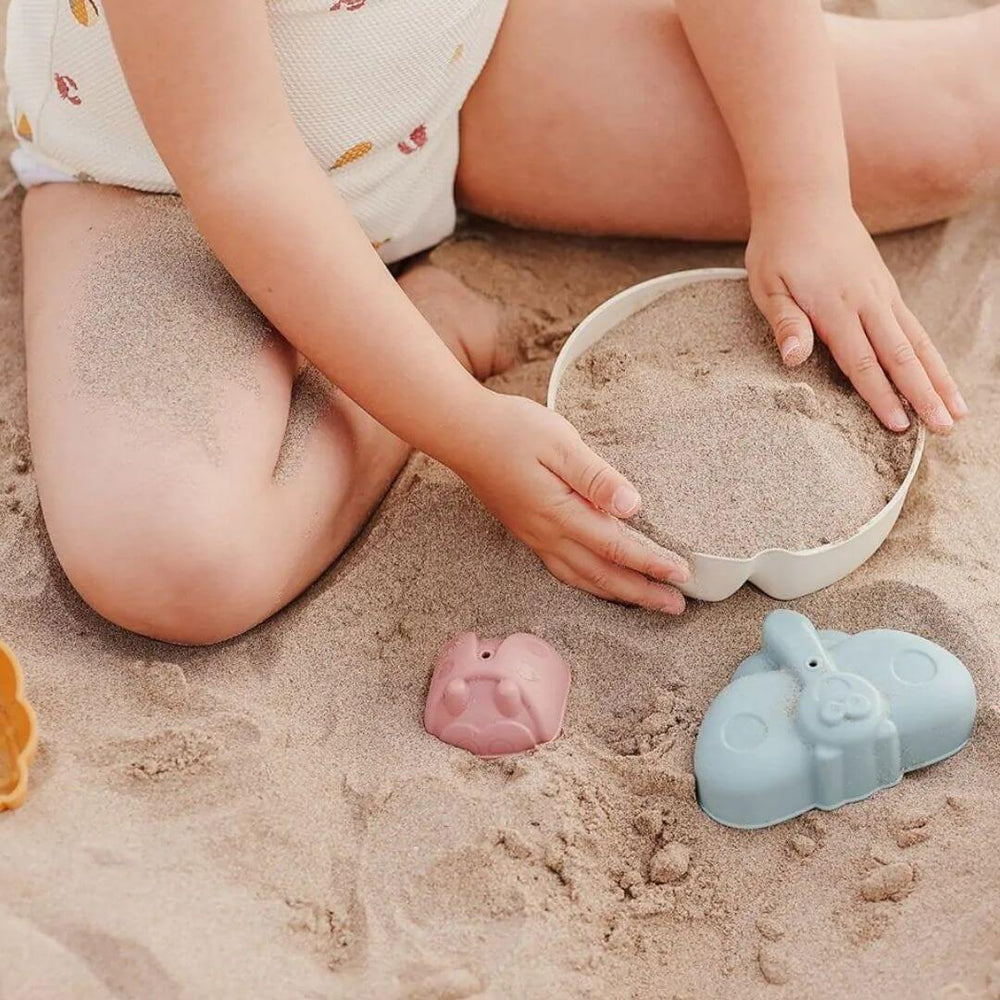 A child fills a sand mold with sand. Miniland - ECO Garden Friends Sand Molds - Bella Luna Toys