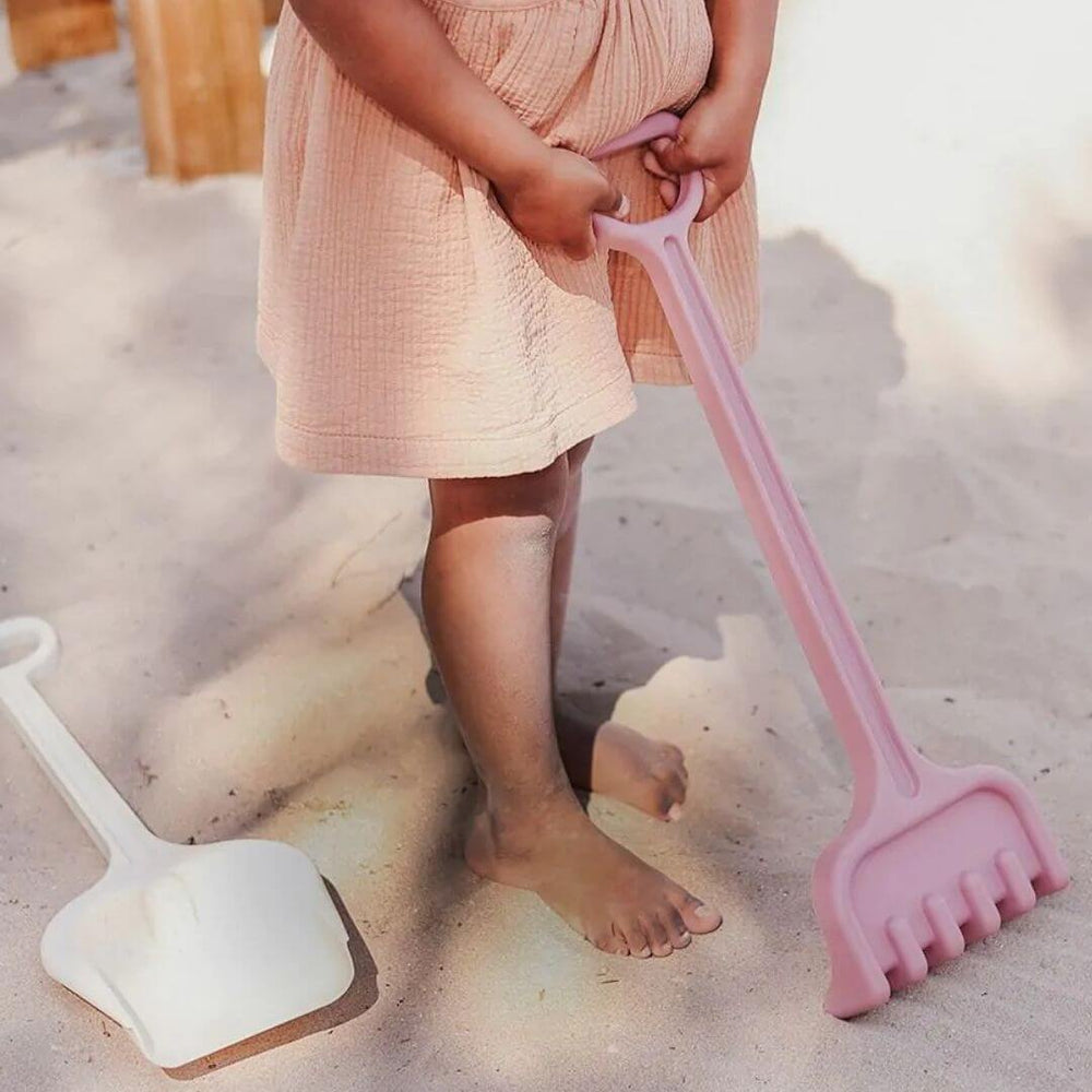Miniland - Child raking sane at the beach with the ECO Rake & Spade Set - Bella Luna Toys