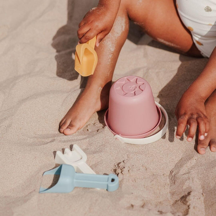 A close shot of a child holding a shovel from the ECO Small Sand Toys 4 Piece Set - Bella Luna Toys