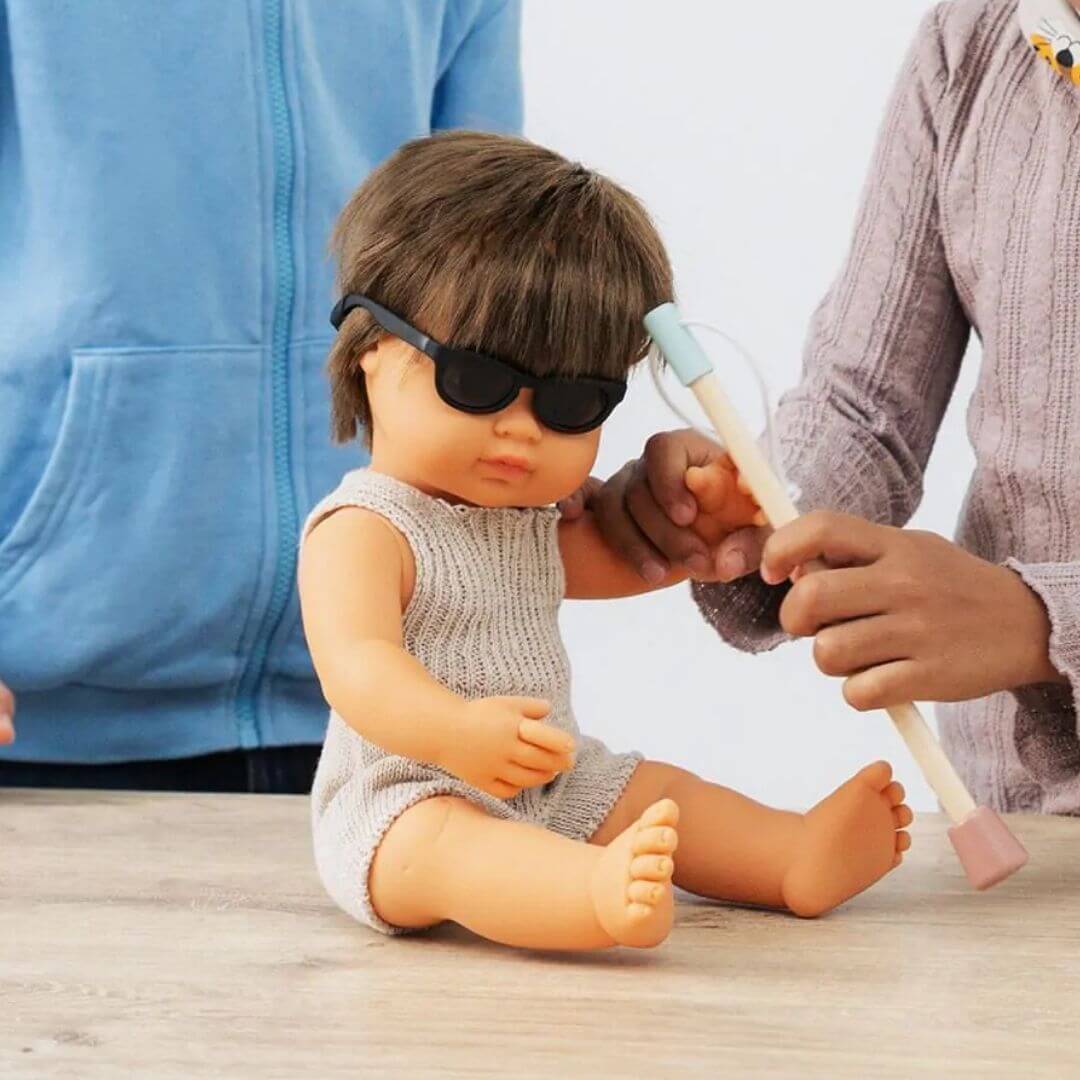 Miniland - Miniland doll wearing the glasses and holding the cane from the Miniland doll accessory set designed to encourage inclusive play, empathy, and social-emotional learning - Bella Luna Toys