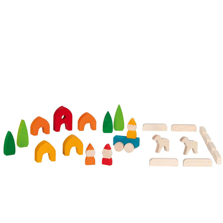 A children's wooden toy set arranged on a white background, including colorful arches, trees, small houses, and natural wood animal and block pieces.