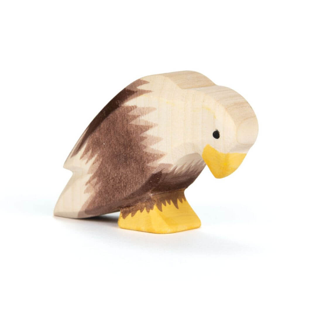 Ostheimer Bald Eagle Sitting handcrafted wooden figure with hand-painted white head, brown body, and yellow beak in a perched pose - Bella Luna Toys