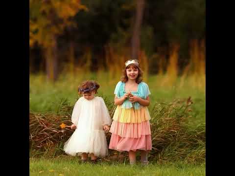 Two girls in costumes are frolicking in an autumn scene.