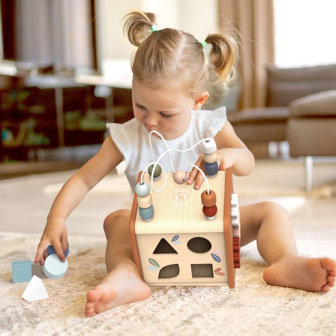 A child sorting shapes into the baby activity cube from Speedy Monkey.