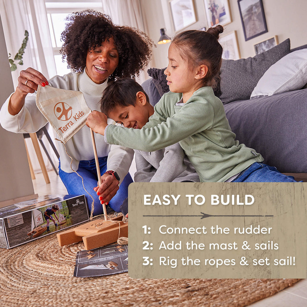 Woman and two children building a toy sailboat set in a living room.