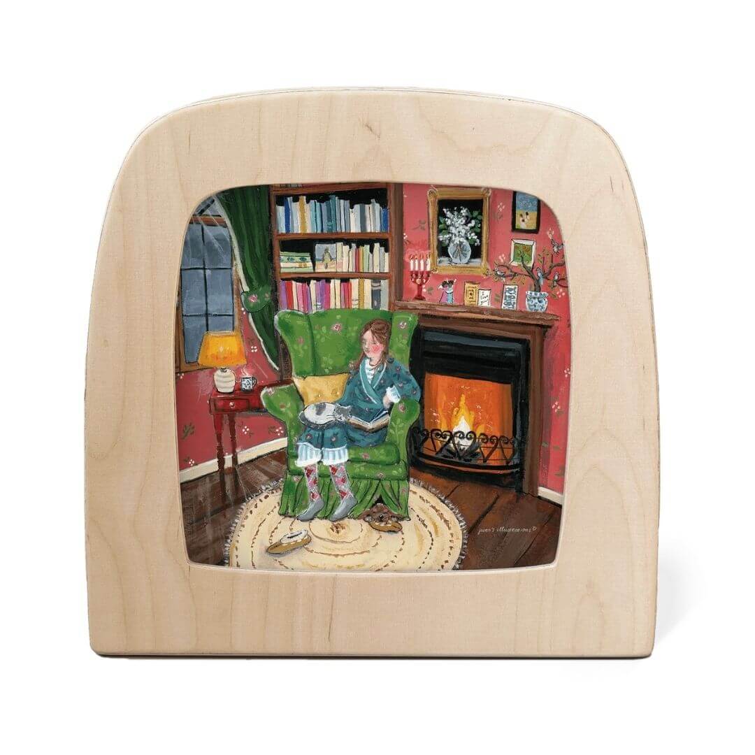 Toverlux Lamp Transparency – “Winter Bliss” by Gwen’s Illustrations, from the Winter Collection. A cozy indoor scene of a woman reading beside a glowing fireplace on a winter’s evening - Bella Luna Toys