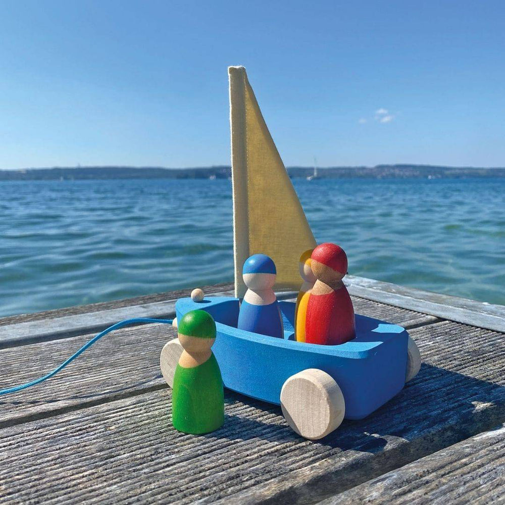 Grimm's Wooden Land Yacht on actual dock with water and land in the background